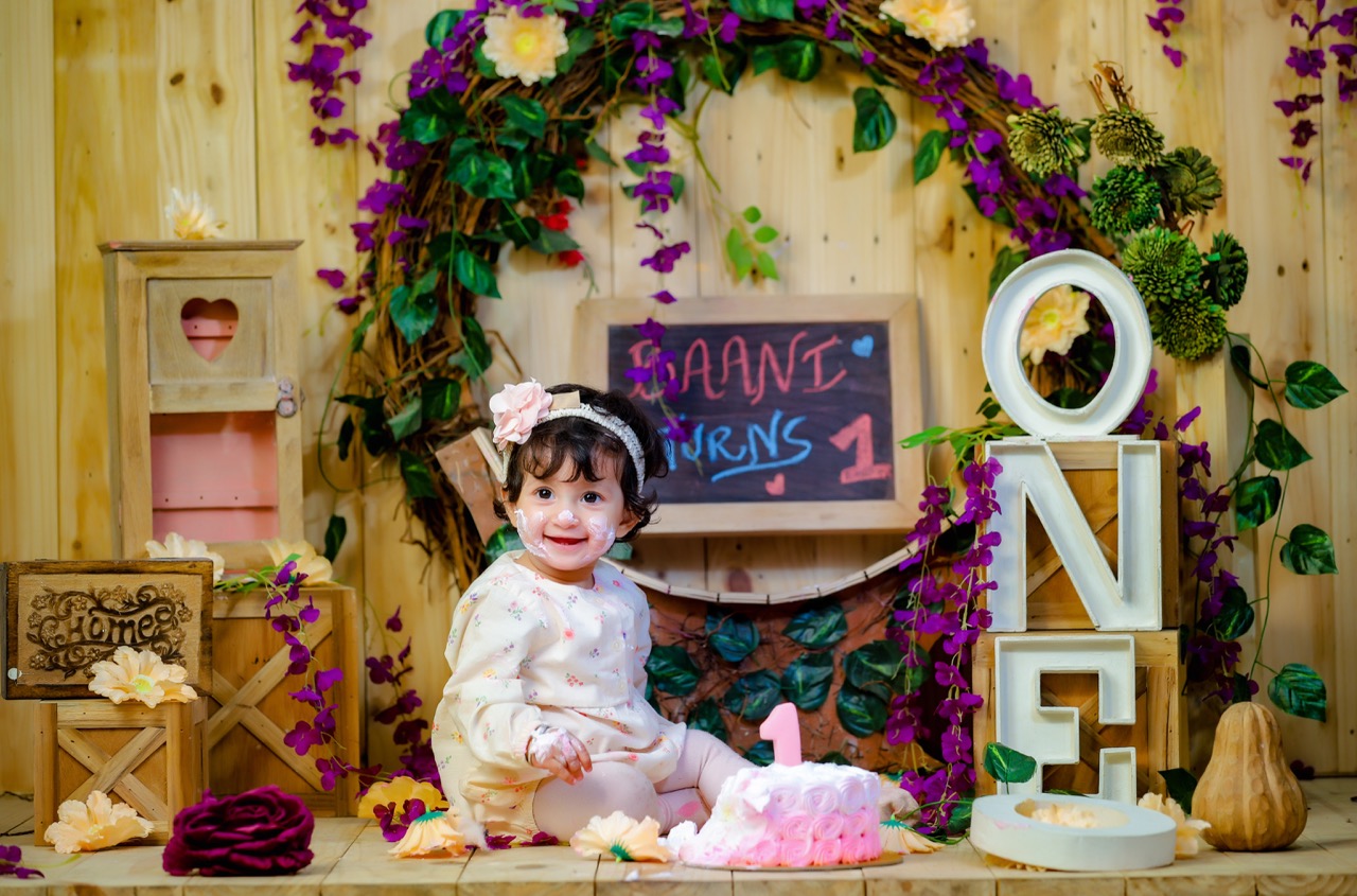 baby photoshoot for a birthday girl with cake smash theme
